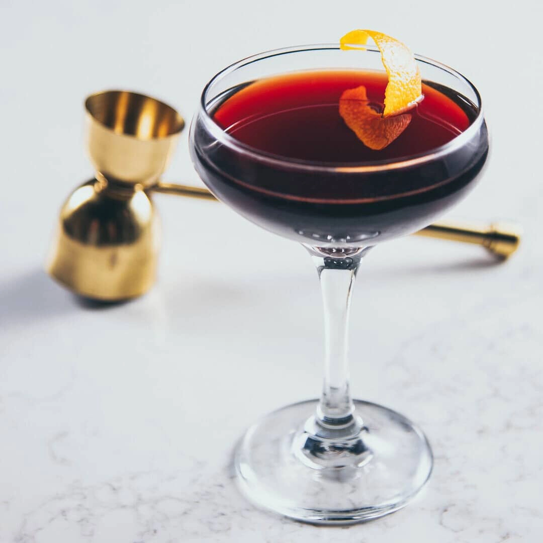 the perfect manhattan with jigger in a champagne glass for the online bartending course